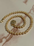 Pearl necklace with a gold clasp on a marble surface